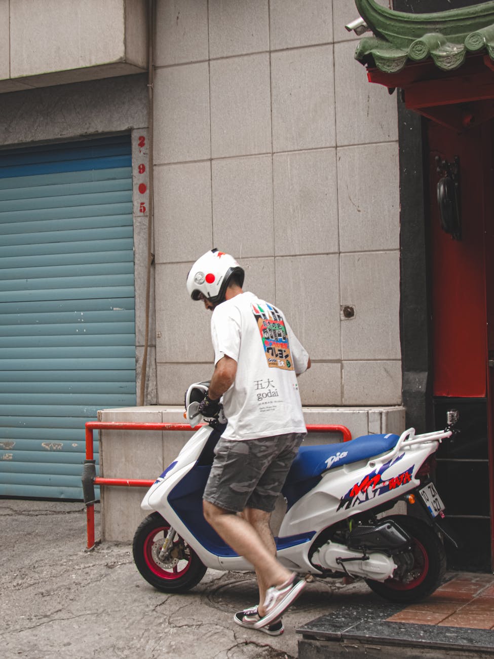 man in helmet getting on moped