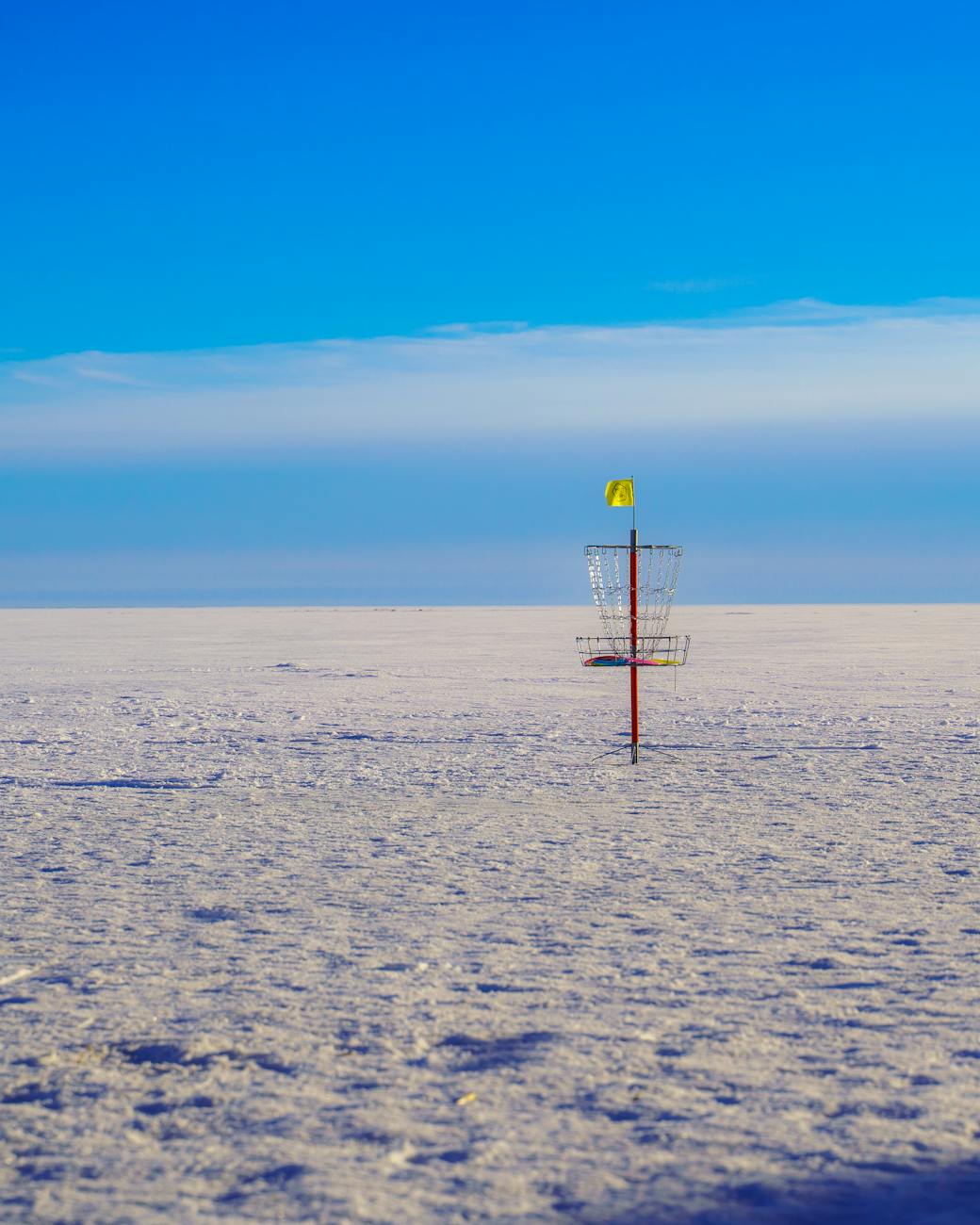 winter disc golf basket in snowy landscape