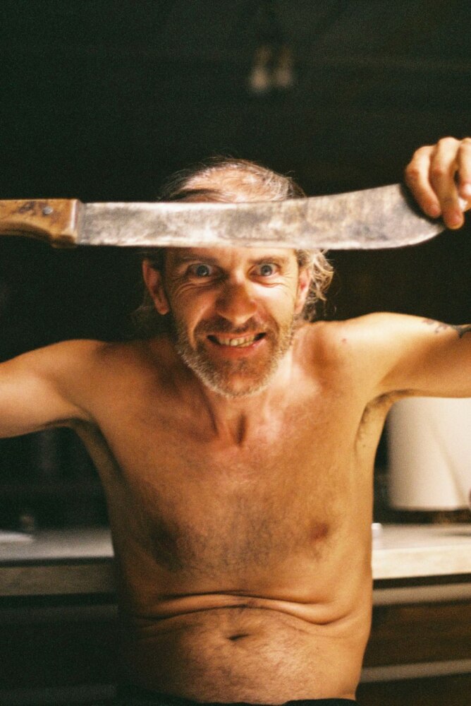 portrait of topless man with machete